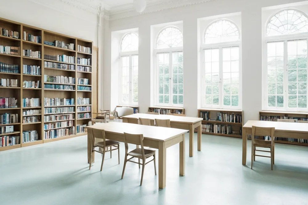 A bright modern library study room with desks